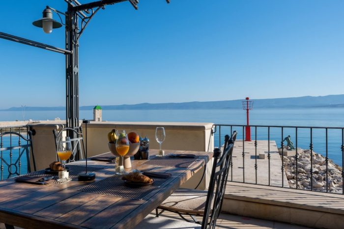 Ugodan aranžman s bocom vina na vanjskoj terasi u zelenilu s pogledom na more