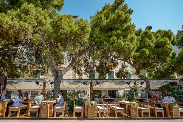 Raskošne zelene krošnje drveća čuvaju mjesta u resoranu od sunca