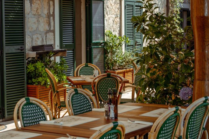 Uredno složeni drveni stolovi restorana čekaju na goste